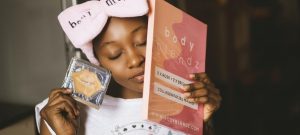 Woman wearing a headband and holding face masks from a subscription kit