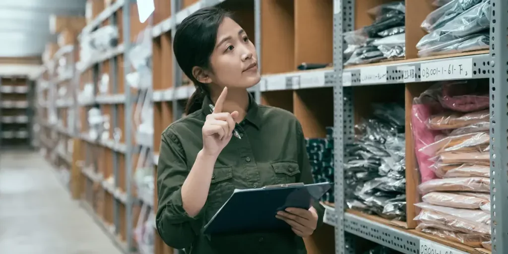 Woman examining inventory on shelves