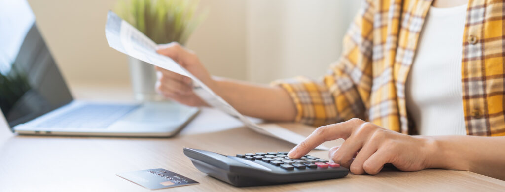Person analyzing paperwork and using a calculator