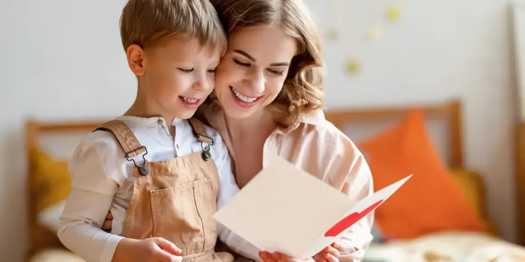Mother and son reading a greeting card smiling.