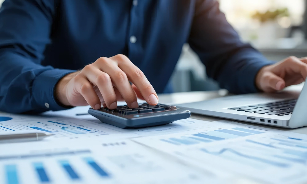 Close up businessman hand using calculator to calculate fulfillment expenses. budget management and accounting on table.