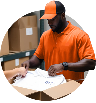Man placing an embroidered shirt into a box in a warehouse.
